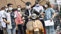 Menteri Perhubungan Budi Karya Sumadi (tengah) menaiki motor vespa yang dimodifikasi menjadi kendaraan listrik di Stasiun Bekasi Timur, Jawa Barat, Minggu (18/4/2021).
