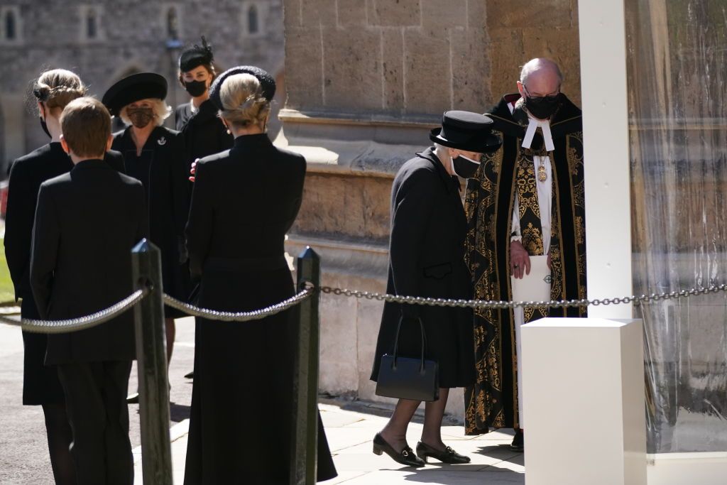 Britain's Queen Elizabeth II follows the coffin in a car as it makes it's way past the Round Tower during the funeral of Britain's Prince Philip inside Windsor Castle in Windsor, England Saturday April 17, 2021. (Leon Neal/Pool via AP)