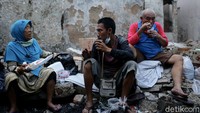 Sejumlah warga tampak berbincang sembari menyantap makanan dan minuman saat tengah berbuka puasa di antara reruntuhan bangunan sisa kebakaran di kawasan Tamansari, Jakarta.