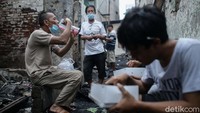 Sejumlah warga korban kebakaran di kawasan Tamansari, Jakarta, berbuka puasa di tengah puing-puing bangunan rumah mereka yang hangus terbakar, Senin (19/4/2021).