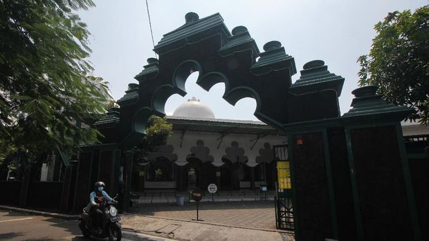 Warga melintas di depan Masjid Rahmat, Surabaya, Jawa Timur, Jumat (16/4/2021). Masjid yang terletak di Jalan Kembang Kuning tersebut merupakan salah satu masjid tua di Surabaya dan peninggalan Sunan Ampel. ANTARA FOTO/Didik Suhartono/aww.
