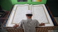 Begini perbandingan Al-Quran raksasa dengan orang dewasa.