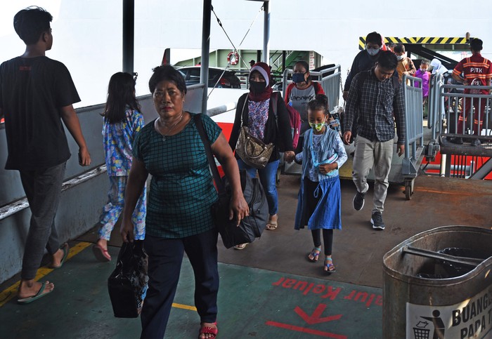 Calon penumpang kapal ferry tujuan Sumatera melintas di Dermaga II Pelabuhan Merak, Banten, Minggu (18/4/2021).  Adanya kebijakan pemerintah yang melarang mudik tanggal 6-17 Mei mendatang untuk mencegah penyebaran COVID-19 mendorong sebagian warga mudik lebih awal. ANTARA FOTO/Asep Fathulrahman/rwa.