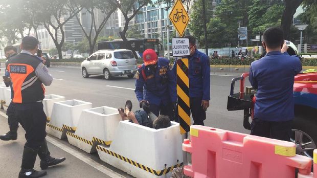 Seorang pria tersangkut di pembatas jalur sepeda permanen jalan Sudirman.