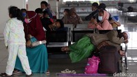 Warga tertidur saat menunggu bus yang akan membawa mereka ke kampung halaman.