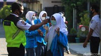 Sebelum memasuki ruang kelas, siswa/i wajib menggunakan masker, diperiksa suhu tubuhnya dan disemprotkan handsanitizer.