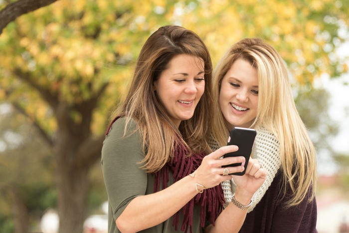 Mother and daughter shopping on their mobile phone.