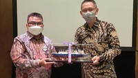 Direktur Utama PT Jawa Satu Regas Indra Trigha menyerahkan replika kapal FSRU Jawa Satu kepada VP Indonesia BP Berau Ltd Hardi Hanafiah saat seremoni transfer perdana kargo LNG ke kapal FSRU Jawa Satu dari Kapal LNG Carrier Tangguh Towuti, Selasa (20/4).