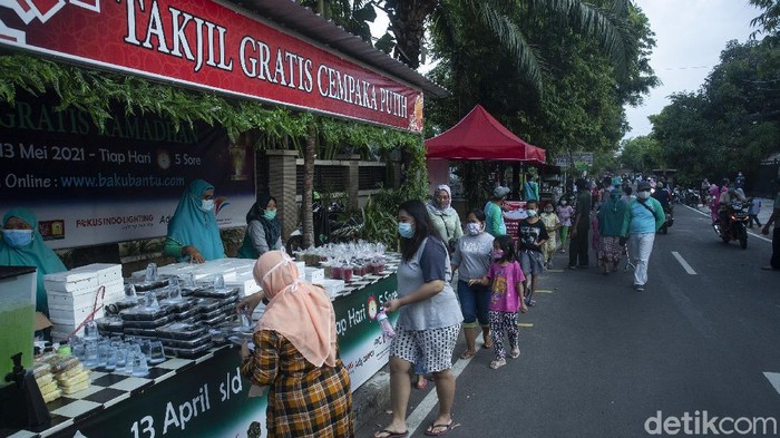 Sejumlah warga mengantre takjil gratis di Cempaka Putih, Jakarta, Selasa (20/4/2021). Ratusan menu berbuka puasa siap diambil bagi warga yang membutuhkan.