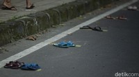Garis-garis kuning berjarak telah diisi oleh sandal-sandal milik warga.  