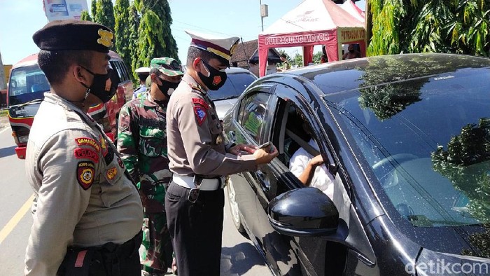 Polisi mengecek pengendara yang melintas ke pintu masuk Jateng di Kabupaten Blora, Selasa (20/4/2021)