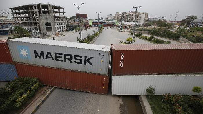 Polisi Pakistan Blokir Jalan Pakai Peti Kemas Shipping containers are placed by authorities to block a road leading to the capital as a security measure on the possible anti-France protest march by a banned radical Islamists Tehreek-e-Labaik Pakistan party, in Rawalpindi, Pakistan, Tuesday, April 20, 2021. Pakistan's Parliament is expected to consider a resolution on Tuesday about whether the French envoy should be expelled over the publication of controversial cartoons depicting Islam's Prophet, testing whether the government gives in to threats from radical Islamists. (AP Photo/Anjum Naveed)