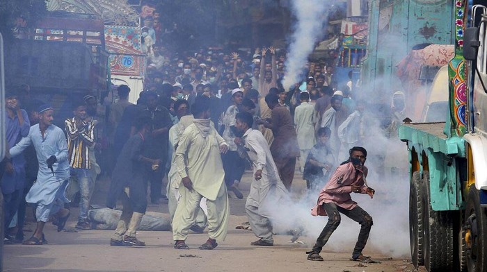Bentrokan antara simpatisan Tehrik-e-Labaik Pakistan (TLP) dan polisi terjadi di Karachi, Pakistan, Senin (19/4/2021) waktu setempat. Dalam bentrokan itu sejumlah massa tampak melemparkan kembali tabung gas air mata yang ditembakkan polisi. AP Photo/Fareed Khan.