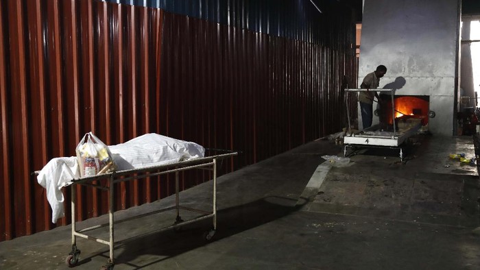 A body of a COVID 19 victim waits to be cremated in New Delhi, India, Monday, April 19, 2021. New Delhi has imposed a weeklong lockdown to prevent the collapse of the Indian capital's health system amid an explosive surge in coronavirus cases. Authorities said Monday that hospitals have been pushed to their limit. India now has reported more than 15 million coronavirus infections, a total second only to the United States. (AP Photo/Manish Swarup)