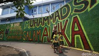 Warga berjalan di depan mural bernuansa Islami di Gang Pelangi, Kalibata, Jakarta Selatan, Rabu (21/4/2021).   