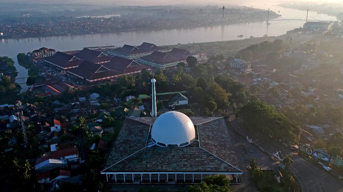 Pekerja membersihkan bagian dalam Masjid Agung Al-Falah atau Masjid Seribu Tiang, Jambi, Rabu (21/4/2021). Masjid yang diresmikan pemakaiannya pada 1980 oleh mantan Presiden Soeharto tersebut dibangun tanpa dinding dan pintu dengan 232 tiang penyangga atap dan kubah. ANTARA FOTO/Wahdi Septiawan/aww.