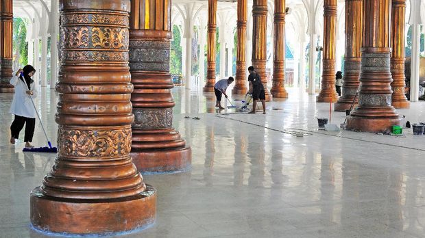 Pekerja membersihkan bagian dalam Masjid Agung Al-Falah atau Masjid Seribu Tiang, Jambi, Rabu (21/4/2021). Masjid yang diresmikan pemakaiannya pada 1980 oleh mantan Presiden Soeharto tersebut dibangun tanpa dinding dan pintu dengan 232 tiang penyangga atap dan kubah. ANTARA FOTO/Wahdi Septiawan/aww.
