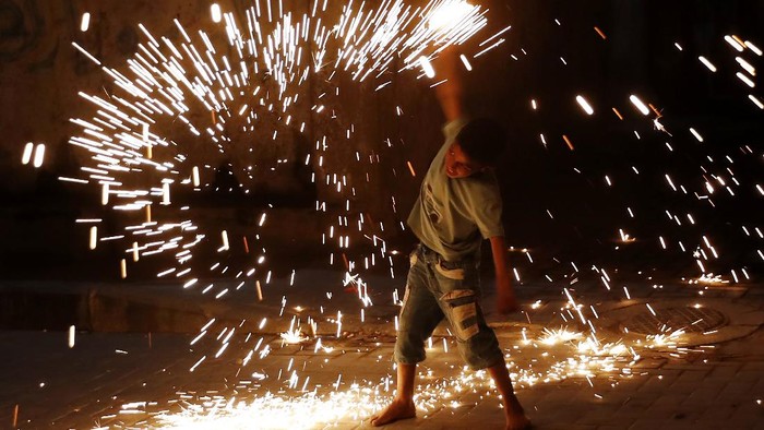 Semarak Ramadhan di Kota Gaza A young boy plays with fireworks as he celebrates during the Muslim holy fasting month of Ramadan along the alley in Gaza City, Tuesday, April 20, 2021. (AP Photo/Adel Hana)