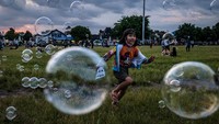 Seorang anak bermain dengan gelembung sabun saat umat Islam bersiap untuk berbuka puasa di Alun-alun Kidul, Yogyakarta.  