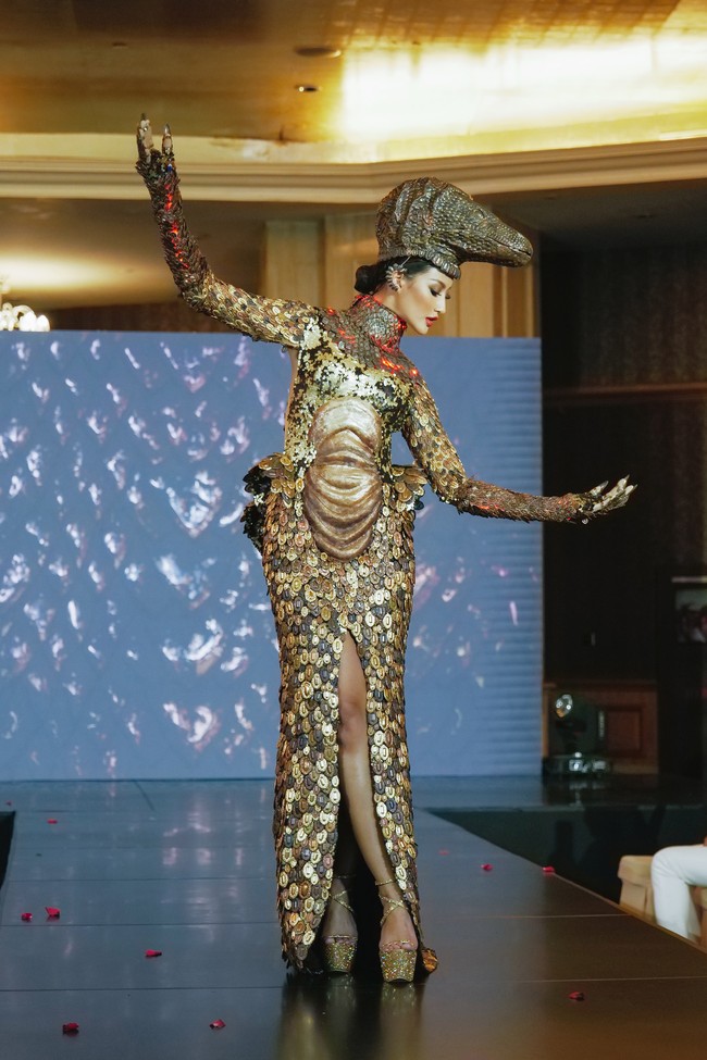 Terakhir, Ayuma memeragakan salah satu busana yang sangat dinanti-nantikan para penggemar. Inilah kostum komodo untuk penilaian National Costume Miss Universe 2020. Komodo sebagai salah satu dari keajaiban dunia menjadi alasan utama untuk tema National Costume dari Indonesia. Hanya ada di Indonesia dan ini termasuk binatang yang langka. Oleh karena itu, saya harap kostum ini bisa membangkitkan kesadaran kita untuk lebih peduli dalam upaya pelestarian alam ndonesia, sekaligus memperkenalkan keunikan Indonesia kepada dunia, katanya. (Foto: dok. Miss Universe/GLADYPHOTOGRAPH)
