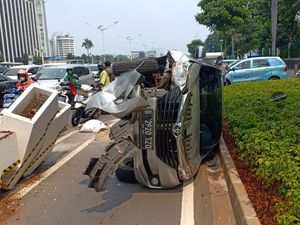Mobil Terguling Usai Tabrak Pembatas Jalur Sepeda di Sudirman