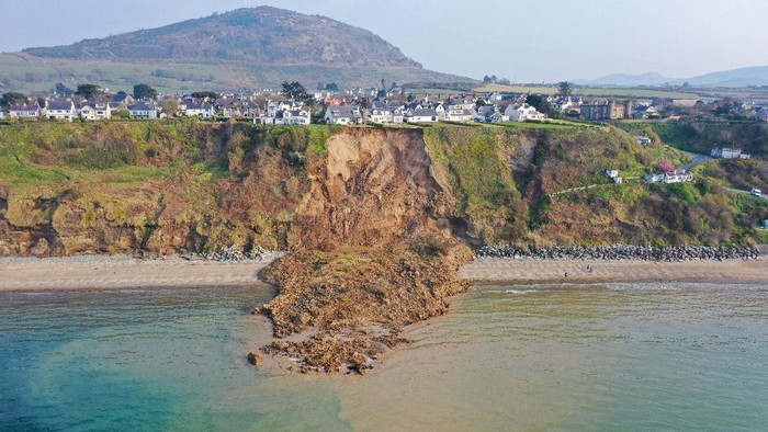Penampakan Tebing Longsor di Pantai Wales NEFYN, WALES - APRIL 21: In an aerial view houses are seen next to the cliff edge after a landslide at Nefyn Beach in Gwynedd, North Wales on April 21, 2021 in Nefyn, United Kingdom. Following the large land slip people were advised to temporarily relocate. (Photo by Christopher Furlong/Getty Images)