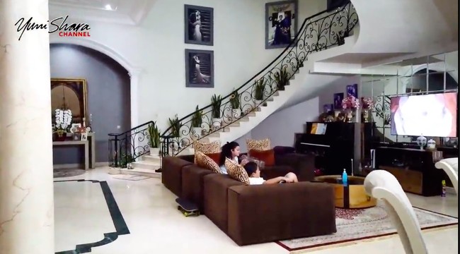 Yuni Shara beberapa kali mengabadikan momen ketika berkunjung ke rumah adiknya, Krisdayanti, untuk konten YouTube. Bak istana, rumah Krisdayanti memiliki sebuah tangga yang megah. Di bawahnya terdapat area berkumpul keluarga untuk menonton bersama.   (Foto: YouTube/Yuni Shara Channel)