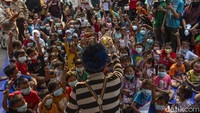 Puluhan anak-anak nampak duduk dengan rapi dan mengenakan masker, antusias yang besar membuatnya sulit untuk menjaga jarak. Dari anak-anak hingga orang dewasa turut menikmati aksi para badut.