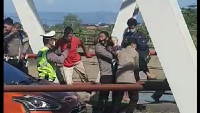 Tangkapan layar video viral penyelamatan wanita yang duduk di tepi jembatan Kudus