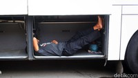 Seorang kondektur bus tengah menunggu penumpang.
