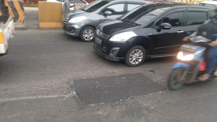 Lubang di Jl KH Noer Ali Dekat Grand Kota Bintang Bekasi ditambal dengan aspal.