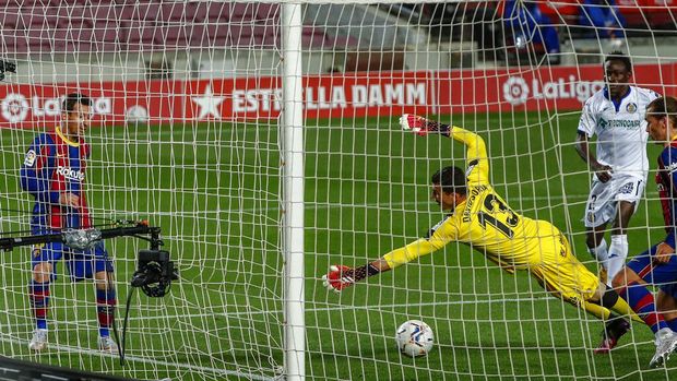 Barcelona's Lionel Messi, left, scores his second goal during the Spanish La Liga soccer match between FC Barcelona and Getafe at the Camp Nou stadium in Barcelona, Spain, Thursday, April 22, 2021. (AP Photo/Joan Monfort)