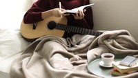 Ditemani secangkir kopi, Maudy tampak serius bermain gitar dan bernyanyi. Tak heran nih Maudy disebut sebagai aktris serba bisa. Foto: Instagram Maudy Ayunda