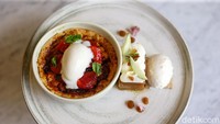 Untuk menutup santapan, cobalah baked cheesecake. Dessert dingin hangat ini berisi crumble, cheesecake, dan stroberi. Toppingnya memakai yogurt sorbet. Ada juga tambahan brown sugar yang di-torched untuk menghasilkan warna cokelat yang cantik. Foto: Grayndos Zafna/detikFOTO