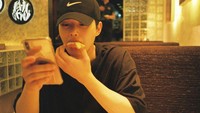 Berpose candid, ini gaya Song Kang saat makan di restoran. Berpose main handphone sambil menikmati makanan di tangan kanannya. Foto: Instagram @songkang_b