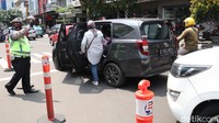 Terlihat sejumlah petugas kepolisian yang melakukan pengaturan arus lalu lintas di jalan tersebut.