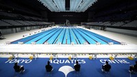 Staf Penyelenggara Olimpiade Tokyo 2020 mempersiapkan acara tes renang Paralimpiade di Tokyo Aquatics Center, Jepang, Senin (26/4/2021) waktu setempat.  