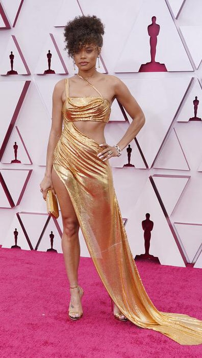 Gaun emas menjadi andalan penyanyi Andra Day yang masuk nominasi aktris terbaik Oscar 2021 berkat penampilannya sebagai penyanyi Billie Holiday. Sumber inspirasi untuk gaun seksi tersebut adalah lingerie. (Foto: AP/Chris Pizzello)