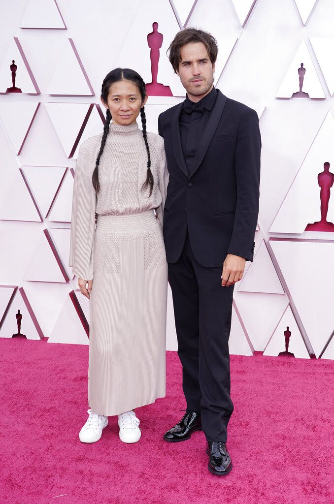 Chloe Zhao, left, and Joshua James Richards arrive at the Oscars on Sunday, April 25, 2021, at Union Station in Los Angeles. (AP Photo/Chris Pizzello, Pool)