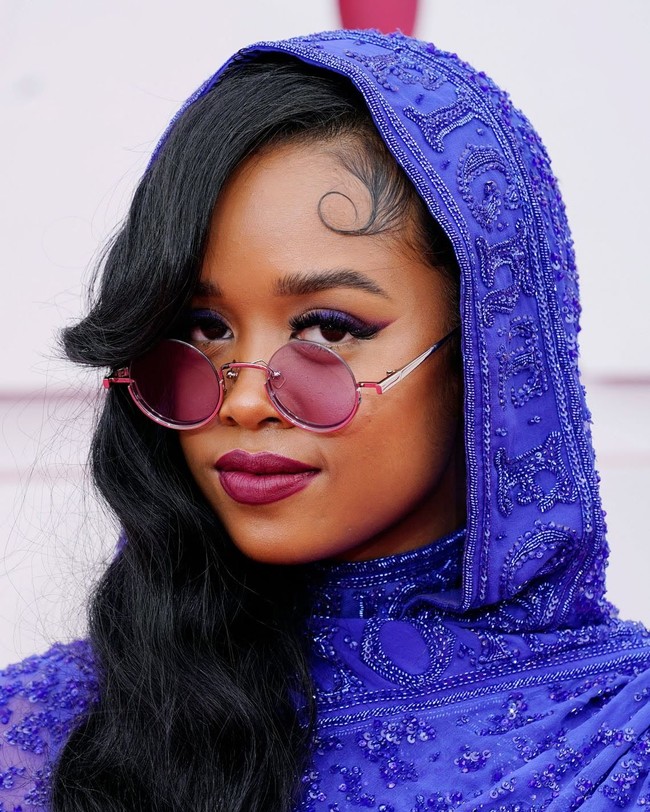 Penyanyi H.E.R datang di karpet merah Oscars 2021 dengan penampilan yang unik. Dari atas sampai bawah, H.E.R konsisten dengan warna ungu, termasuk makeupnya. Garisan eyeliner ungu mempercantik matanya malam itu. Foto: dok. Getty Images