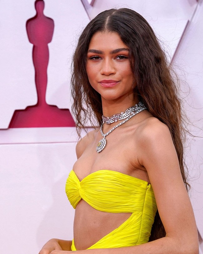 Zendaya membiarkan rambut panjan dan keritingnya terurai. Tak hanya penampilan rambutnya yang tampak natural, namun juga makeupnya. Makeup artist-nya menyebut riasan Zendaya di Oscars 2021 iti adalah makeup i woke up like this. Foto: dok. Getty Images