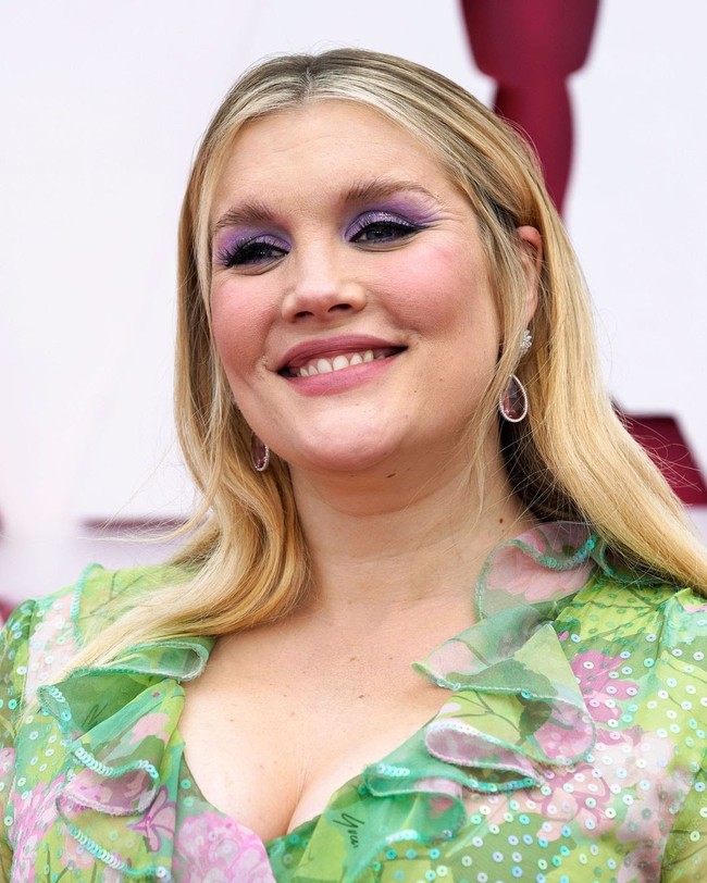 Aktris Emerald Fennel tampil ceria dan semarak dengan gaun bermotif floral. Tampilannya semakin fun dengan eyeshadow ungu. Foto: dok. Getty Images