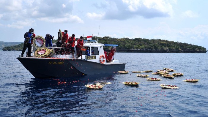 Sejumlah pejabat menaburkan bunga dan melemparkan karangan bunga saat kegiatan Doa dan Tabur Bunga untuk KRI Nanggala 402 di perairan utara Bali, Buleleng, Bali, Senin (26/4/2021). Kegiatan tersebut dilakukan untuk mendoakan dan memberikan penghormatan bagi seluruh awak KRI Nanggala 402 yang gugur setelah kapal selam tersebut dipastikan tenggelam di perairan utara Bali. ANTARA FOTO/Fikri Yusuf/hp.