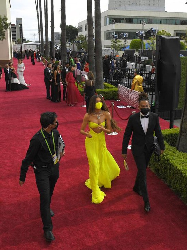 Saat berjalan ke red carpet, ia tampak mengenakan masker berwarna kuning, senada dengan gaun Valentino yang dikenakannya. Foto: Dok. AP