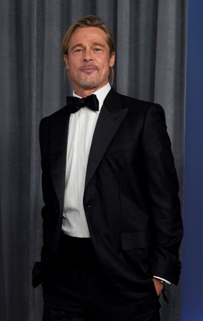 Warga Twitter dibuat heboh karena rambut cepol Brad Pitt di Oscars 2021. Meskipun terkesan ditata asal, gayanya tetap terlihat elegan. Foto: Getty Images via AFP/POOL