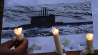 Sejumlah lilin tampak menghiasi gambar yang menampilkan kapal selam KRI Nanggala-402 saat doa bersama digelar di Banyuwangi. ANTARA FOTO/Budi Candra Setya.