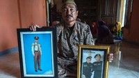 Edy Sujianto memegang foto anaknya Lettu Laut (P) Imam Adi yang telah pergi untuk selamanya. Juni Kriswanto/AFP.
