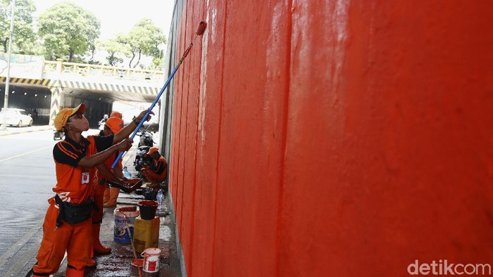 Sejumlah petugas menata dinding kolong jembatan Tanah Abang, Jakarta Pusat, agar terlihat bersih dengan melakukan pengecatan baru berwarna oranye.