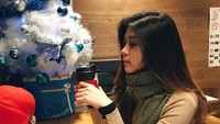 Jalan-jalan ke luar negeri saat liburan Natal, Novita menikmati segelas minuman hangat. Suasana khas Natal benar-benar terasa ya! Foto: Instagram novitacondro