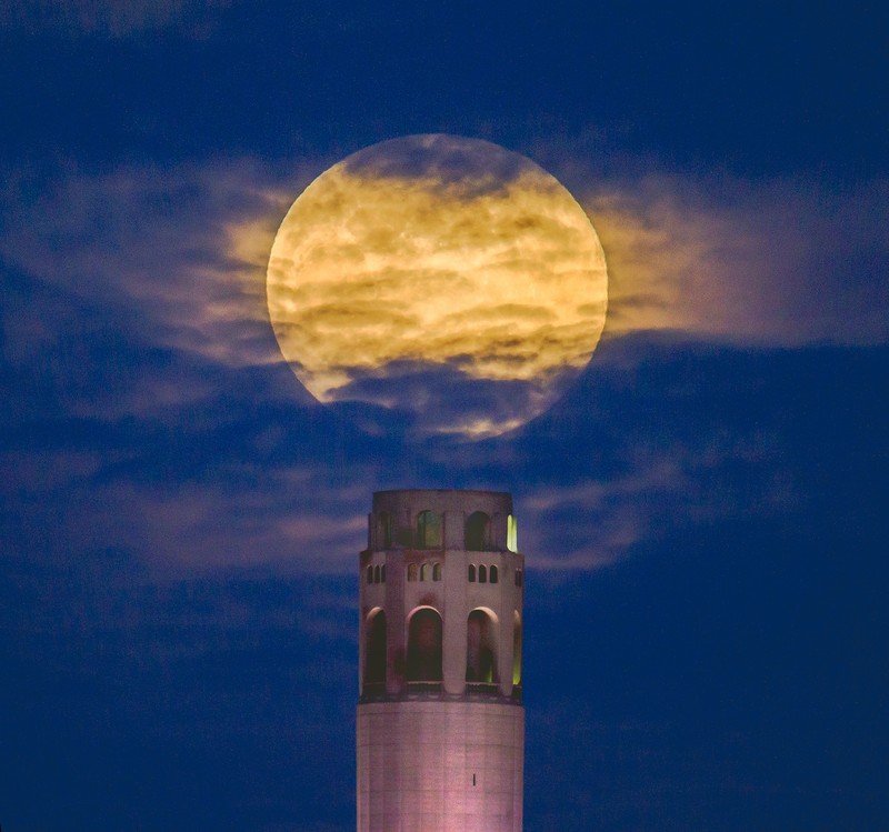 A pink supermoon rises in the night sky over Coit Tower in San Francisco on Monday, April 26, 2021. The full moon in April is known as the 
